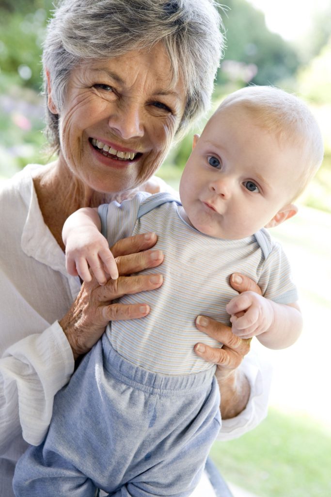 Grandmother outdoors holding grandchild
